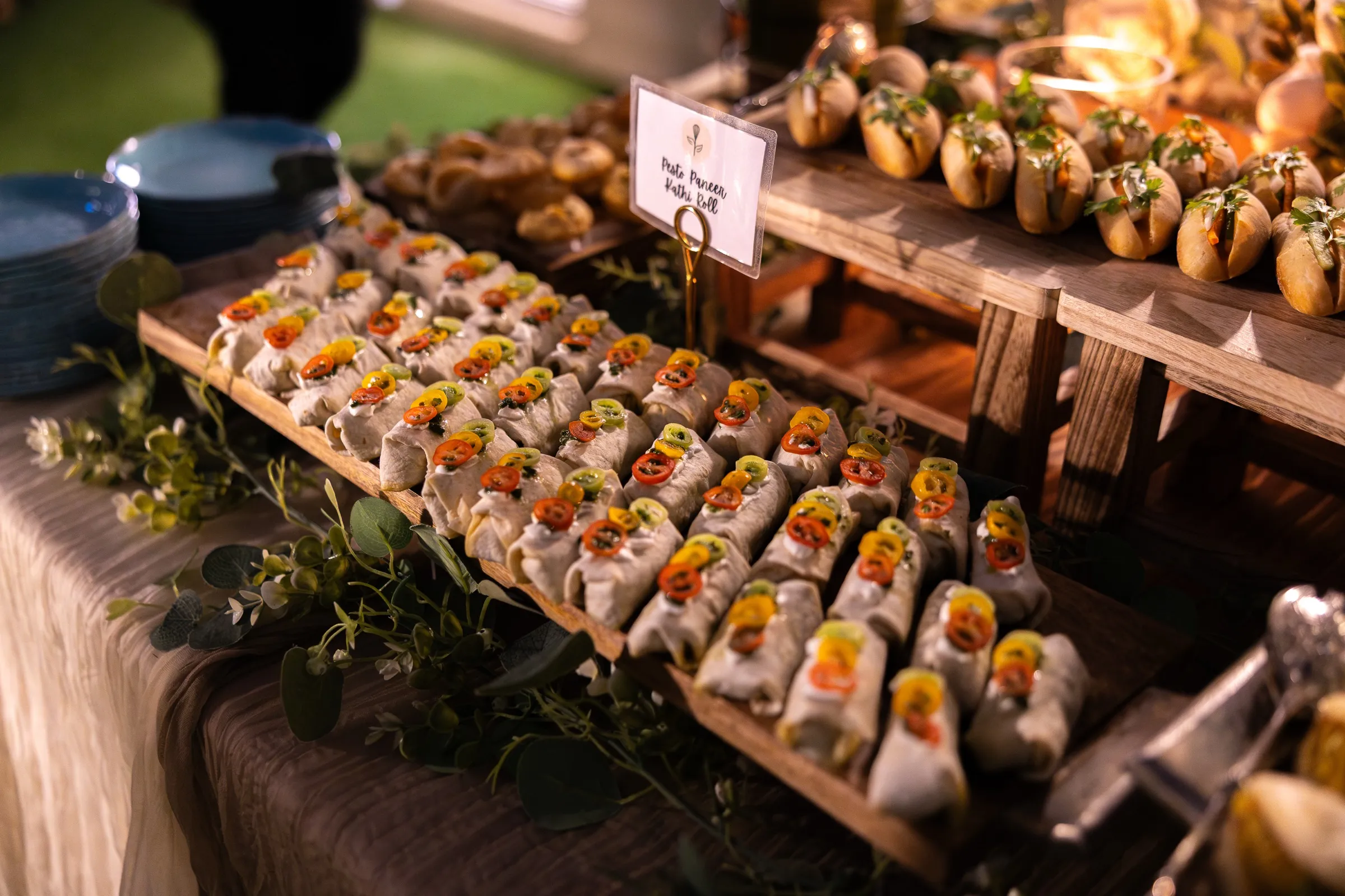 Rows of individually plated canapés arranged along a serving board at an event