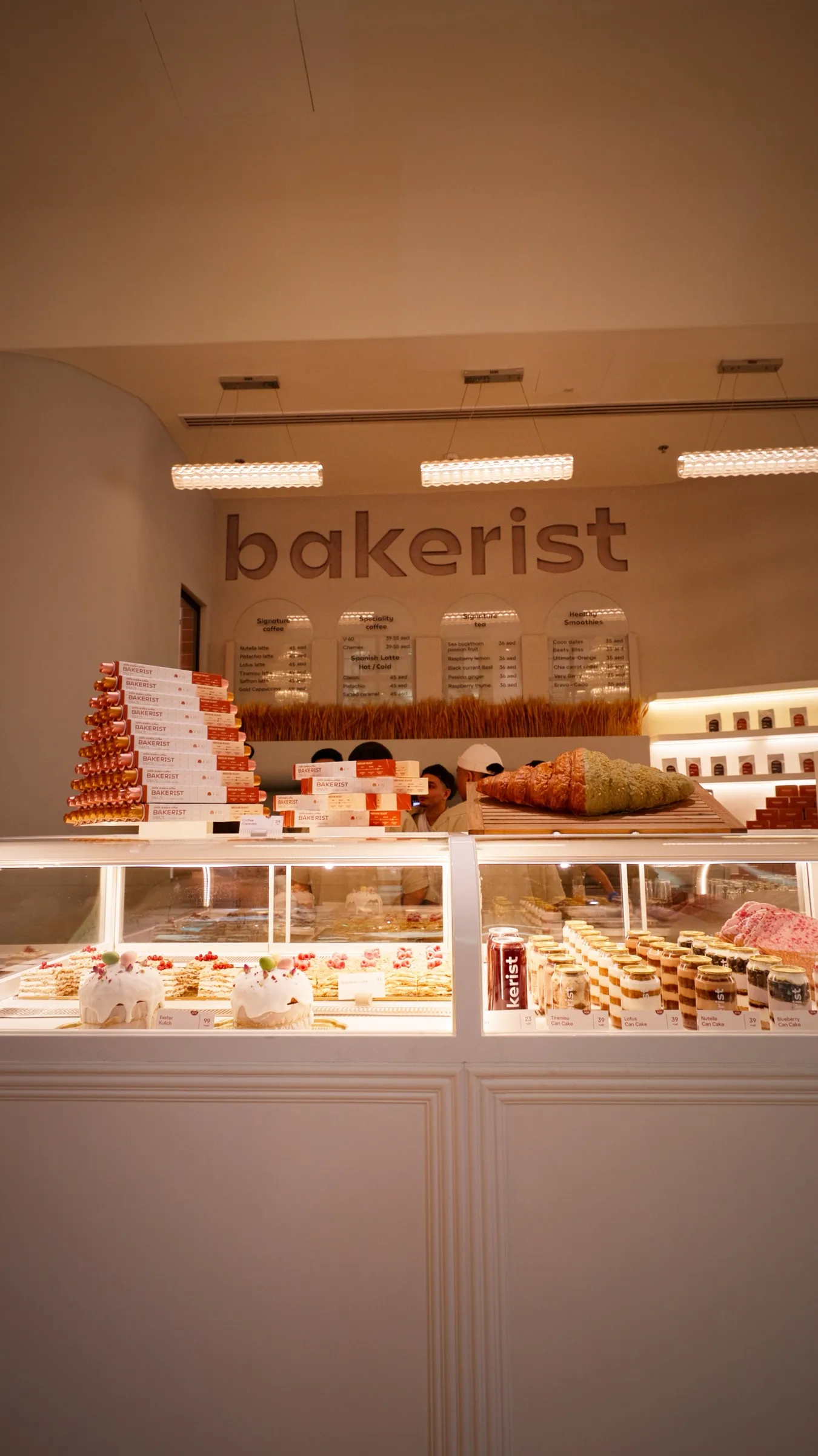 A patisserie counter filled with cakes and pastries in a bright retail bakery